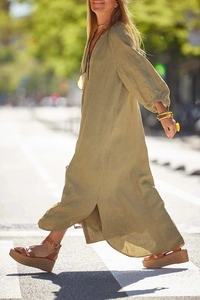 Olive green linen maxi dress featuring a side split and long sleeves in outdoor setting