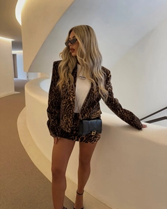 Detail of a chic leopard print blazer suit with a matching mini skirt and chain bag