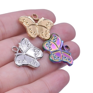 Detail of three stainless steel butterfly pendants in gold, silver and iridescent finishes