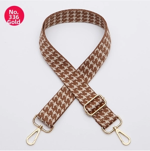Detail of adjustable wide shoulder strap with brown houndstooth pattern and gold hardware