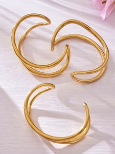Dettaglio di bracciali rigidi aperti in acciaio inossidabile placcato oro 18 carati