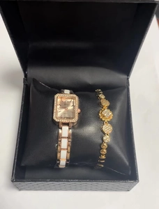 Detail of rose gold square watch and clover bracelet in a premium black gift box