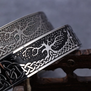 Vintage stainless steel open bangle featuring Celtic tree of life relief on mesh texture