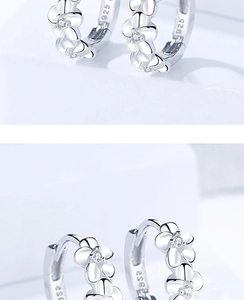 Détail macro de boucles d'oreilles camélia en argent S925 avec zircons blancs et fleurs