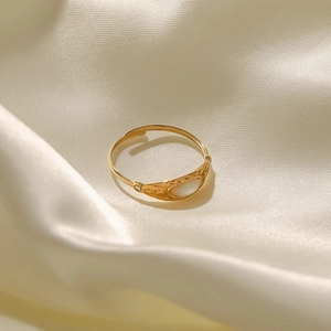 Detail of vintage French gold ring featuring oval shell inlay and zircon accent