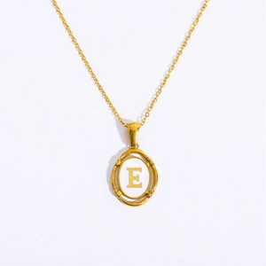 Detail of gold oval pendant with white inlay and golden letter E on fine chain