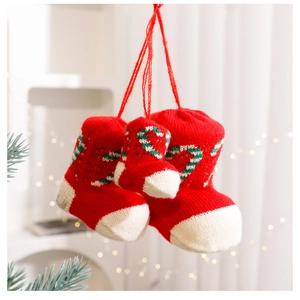 Close-up of three red knitted Christmas stockings with candy cane patterns and warm lighting