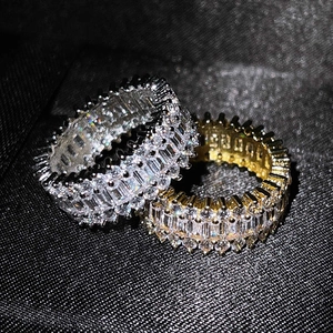Macro shot of silver and gold eternity rings with cubic zirconia on a black texture