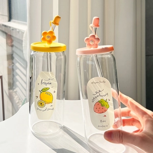 Close-up of glass tumblers with lemon and strawberry prints and cute flower straw caps