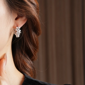 Detail view of French vintage U-shaped earrings with zircon and pearls on model