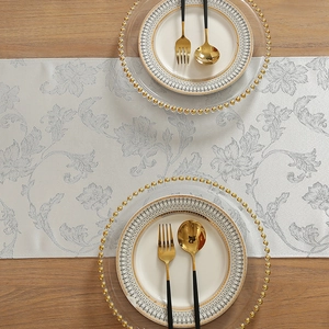 Silver floral jacquard Christmas table runner on wooden table with elegant dinnerware