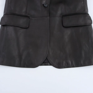 Detail of black PU leather jacket featuring flap pockets and rounded hemline design