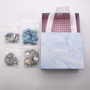 Blue marble gift box with DIY jewelry components including charms and blue beads