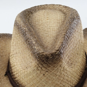 Dettaglio del cappello da cowboy in paglia vintage con finitura usurata e corda intrecciata
