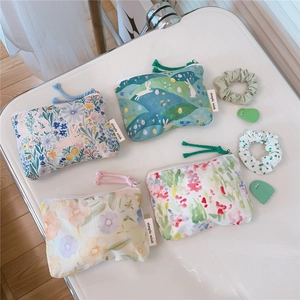 Macro detail of floral cotton mini coin purses with zipper closures and woven labels