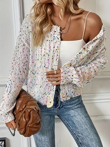 Dettaglio del cardigan bianco in maglia con coriandoli con collane e borsa trapuntata marrone