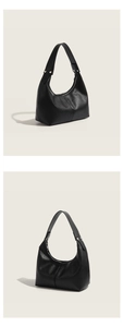 Detailed view of minimalist black leather hobo shoulder bag with soft texture and chic curve.