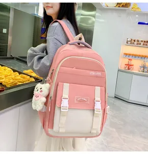 Details des rosa-beigen Schulrucksacks mit Doppelschnallen und Plüschbär-Anhänger