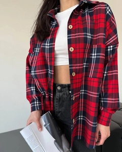 Detailed view of a red and black plaid flannel shirt with front pocket and button closure