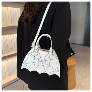 White bat-shaped handbag with spider web stitching shown on model with shoulder strap