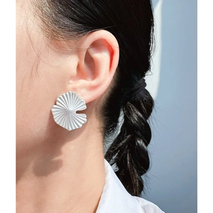Minimalist matte silver ginkgo leaf earrings featuring fan-shaped wrinkled texture on a model