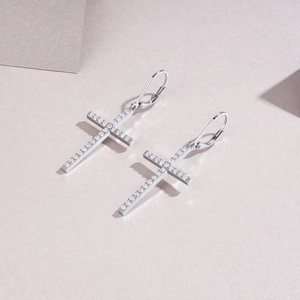 Detailed macro view of silver cross earrings with pavé set white zircon stones