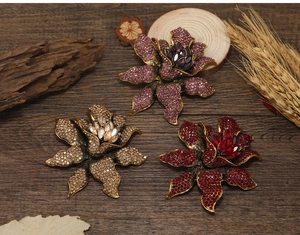 Detailed close-up of vintage rhinestone flower brooches in purple red and champagne colors
