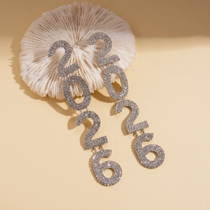 Close-up of silver-tone rhinestone 2026 number earrings on a decorative coral stand