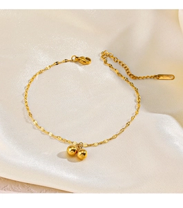 Detail of gold bead stainless steel bracelet with lobster clasp on silk fabric