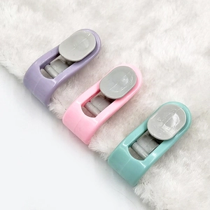 Detailed view of colorful plastic quilt clips in pastel purple pink and blue on plush fabric
