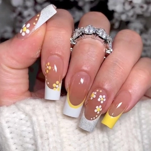 Détails d'ongles ballerine avec marguerites jaunes, paillettes et design français