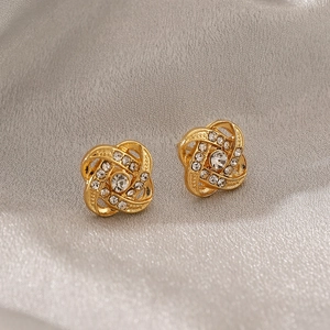Macro detail of gold woven swirl earrings featuring brilliant white rhinestones