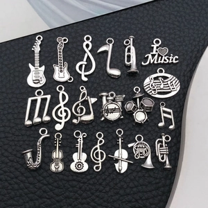 Macro detail of 19 pieces silver alloy musical instrument charms on black leather