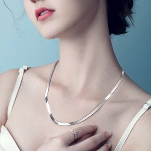 Close-up of polished S925 sterling silver flat snake chain worn on a model's neck