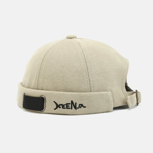 Close-up of khaki docker hat showing XEE Na embroidery and metal adjustment buckle