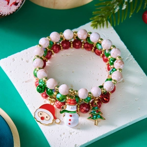 Nahaufnahme von Weihnachtsperlenarmbändern mit Anhängern auf einem Steinsockel