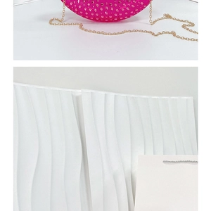 Detailed close-up of pink rhinestone clutch bag with elegant golden chain and textured surface