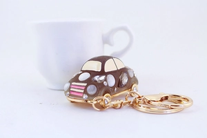 Detailed close-up of a sparkling rhinestone car keychain with cat eye gems and gold hardware