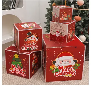 Close-up of stacked red Christmas gift boxes with festive Santa Claus and snowman patterns