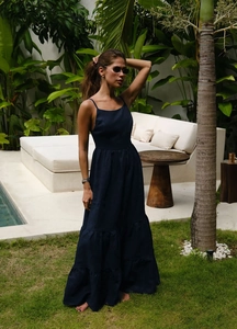 Détail d'une robe maxi bleu marine avec de fines bretelles et une jupe longue à volants