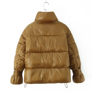 Detail of winter yellow quilted puffer jacket featuring high collar and glossy fabric
