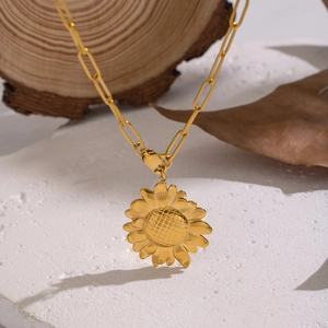 Elegant gold sunflower pendant necklace with oval link chain on a natural stone background