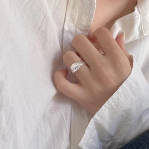 Detailed view of irregular hammered texture on S925 sterling silver ring worn on finger