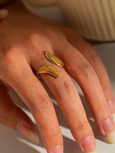 Detail of adjustable gold leaf ring featuring intricate feather textures and metal luster
