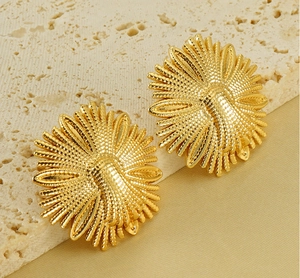 Detailed close-up of vintage golden sunflower earrings with textured metal on stone