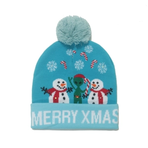 Detail of blue Christmas knit hat with snowman and alien pattern and Merry Xmas text