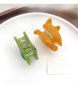 Detail of forest animal acetate hair claws in translucent green and marble orange textures