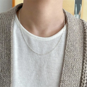 Close-up of a minimalist silver 925 thin chain necklace worn by a model in lifestyle setting