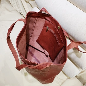 Vue de dessus du cabas en cuir ciré rouge vintage avec poche zippée et texture intérieure