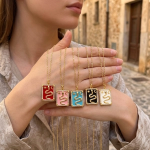 Close-up of five colorful tarot-style snake pendants with zircons and 18k gold plating